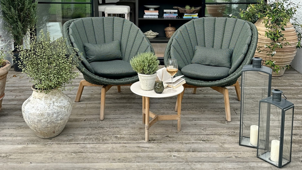 Outdoor dark green lounge chairs with white side table with teak base on the terrace