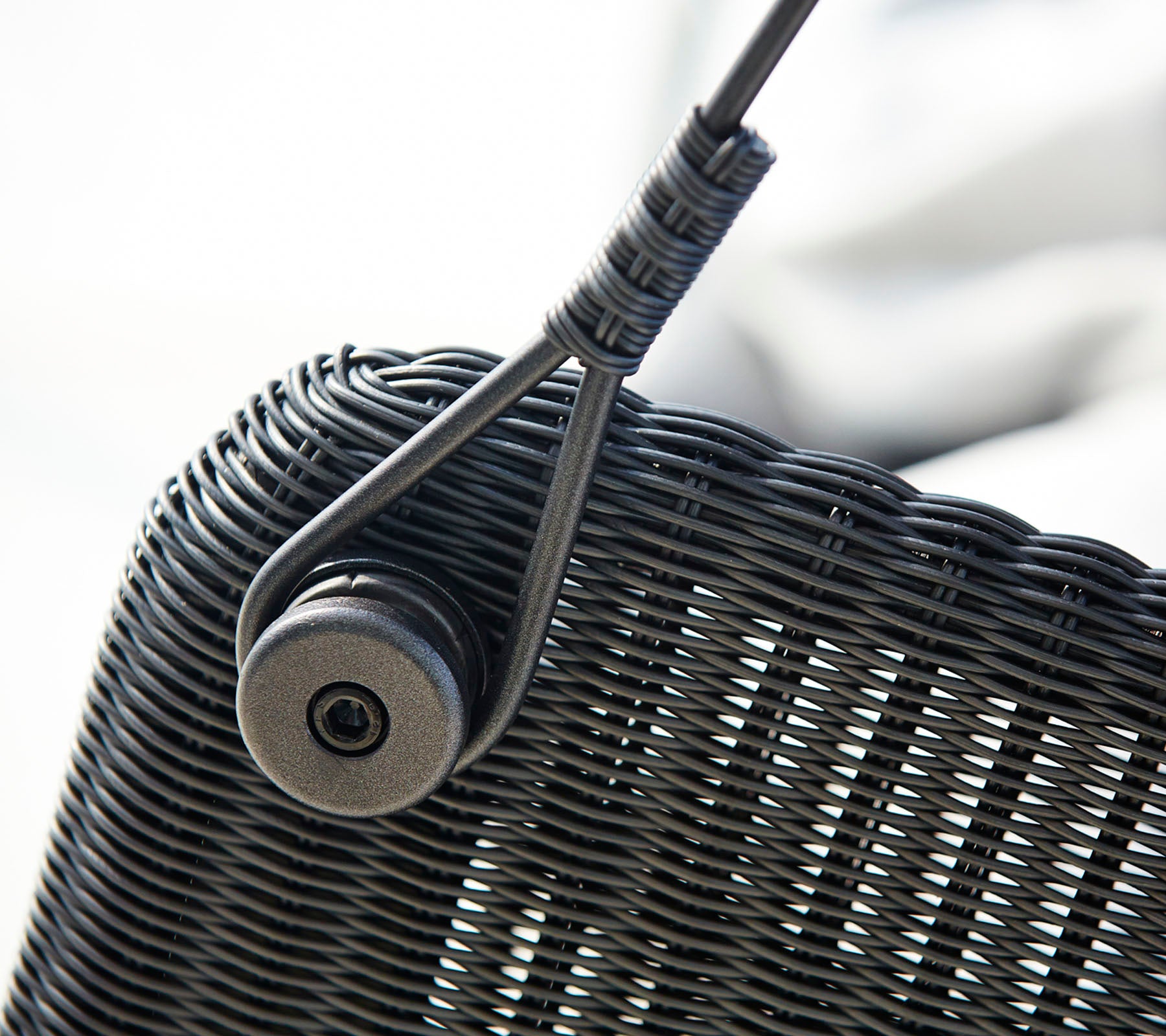 Close-up of a woven texture featuring a circular fastener, showcasing a sleek design element.