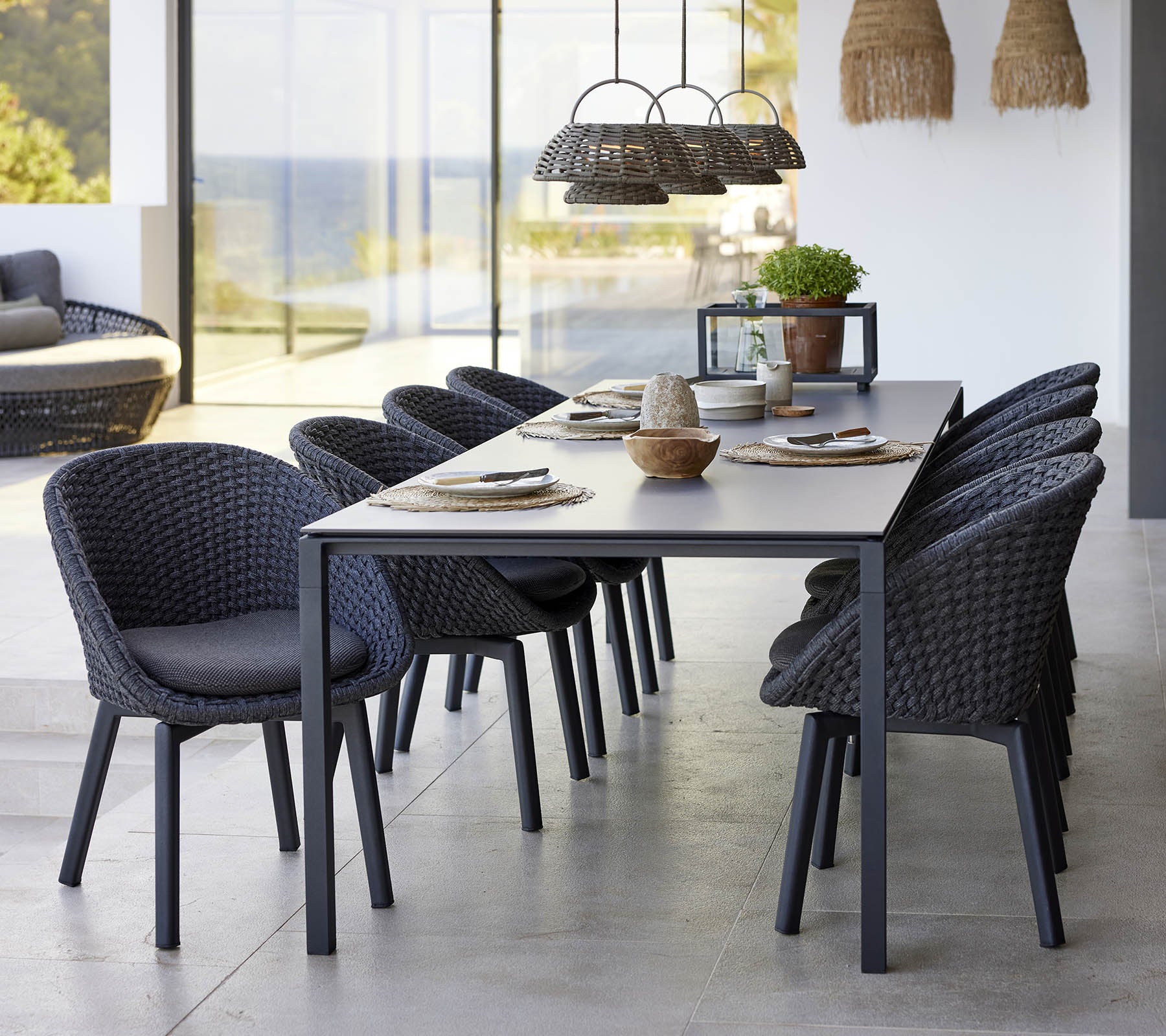A stylish dining setup featuring a pure dining table, peacock chairs, and an illusion lamp, enhancing a modern aesthetic.