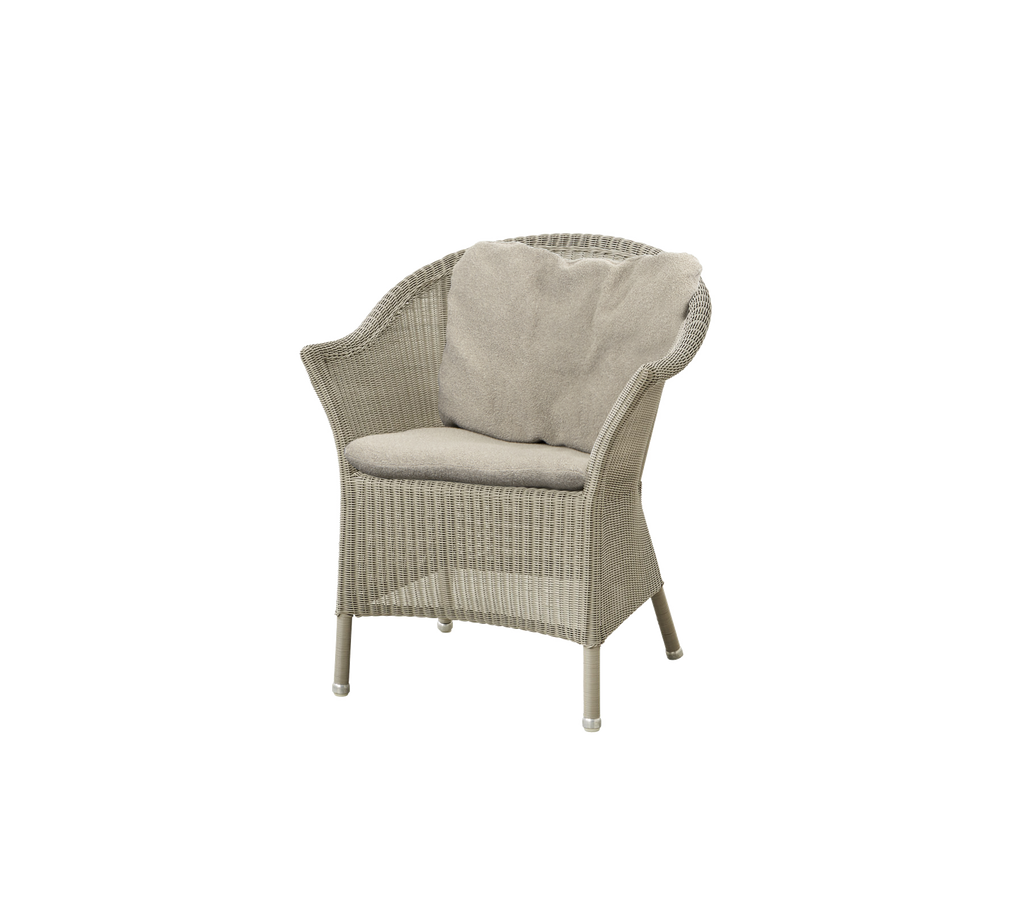 Woven chair with a light-colored cushion, featuring a curved backrest and sturdy legs, perfect for relaxing.