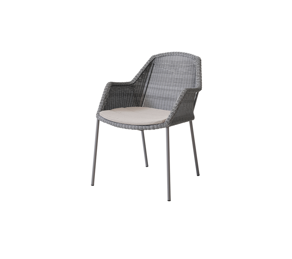Gray woven chair with armrests, featuring a light-colored cushion on a minimalist design, suitable for outdoor or indoor use.