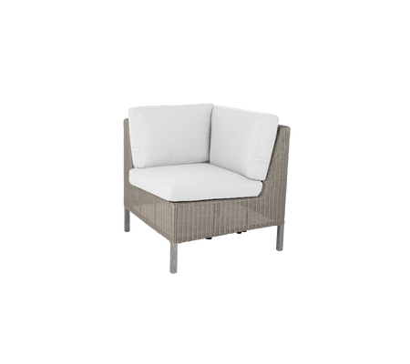 Corner chair with a woven exterior and plush white cushions, perfect for adding comfort and style to any space.
