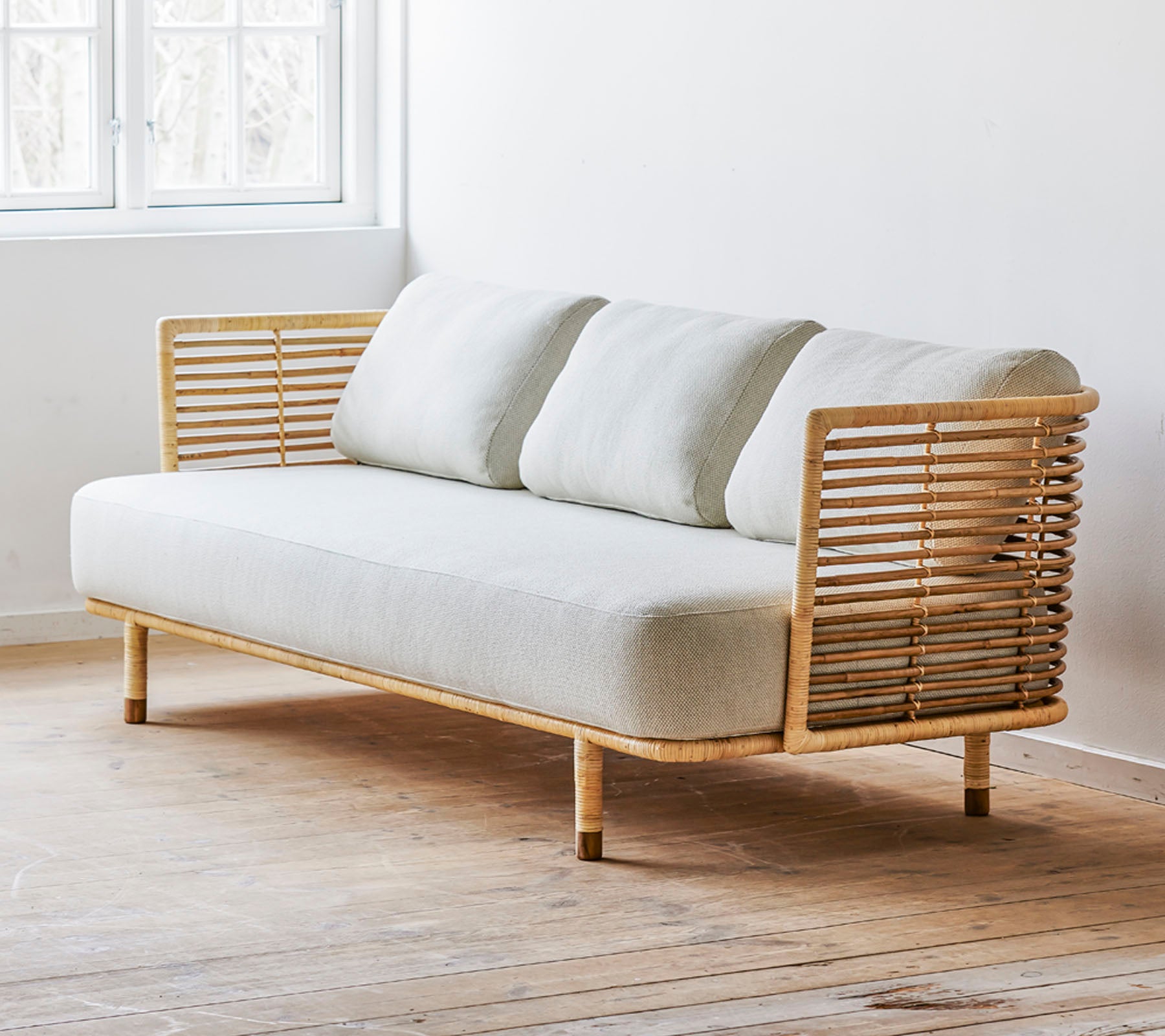 A modern sofa featuring a sleek design with a light fabric seat and stylish wooden side accents. Perfect for contemporary spaces.