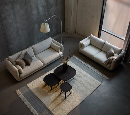A modern sitting area featuring a Bloom 3-seater sofa, a smaller 3-seater sofa, and stylish Pace coffee tables on a textured rug.