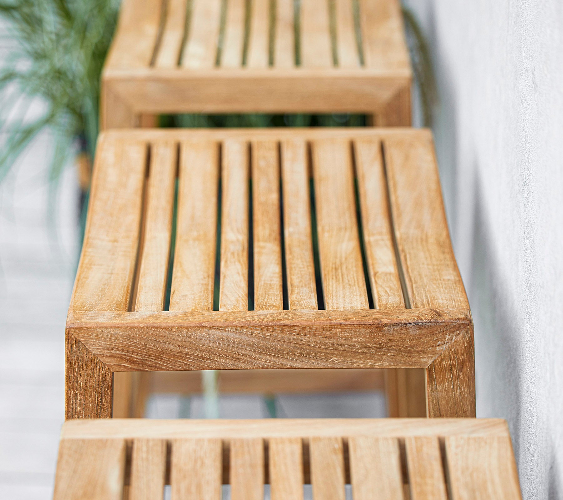 Wooden slatted benches arranged in a row with a minimalist design, showcasing natural textures and finishes. Suitable for various settings.