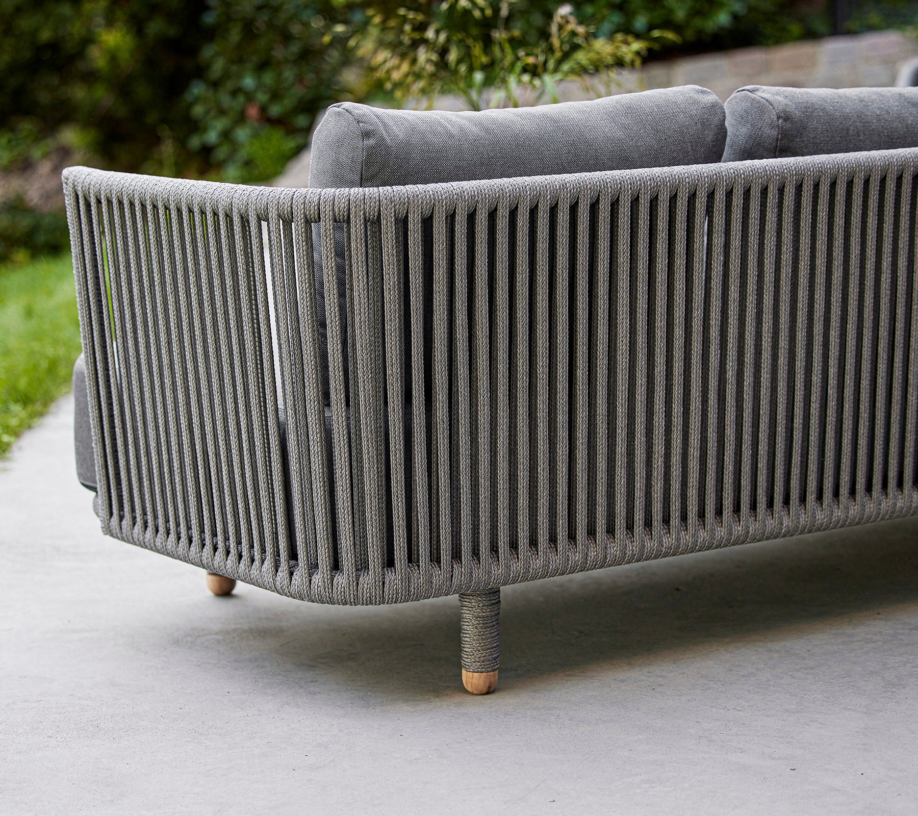 Sleek, modern gray sofa with vertical slat design and wooden legs, ideal for contemporary outdoor or living spaces.
