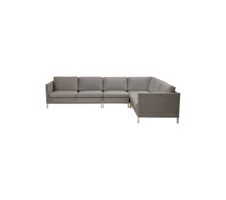 Modern sectional sofa with plush cushions in soft gray upholstery and a woven base, perfect for stylish seating arrangements.