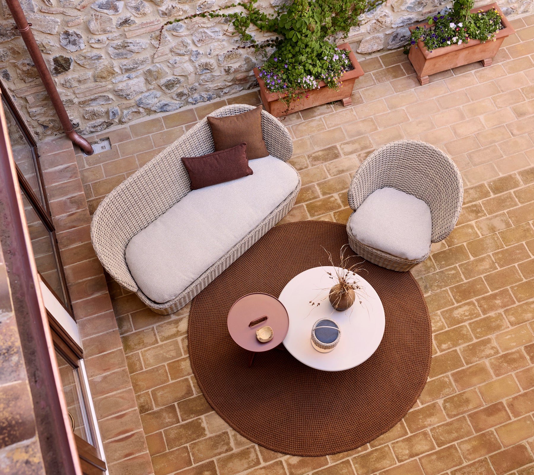Cozy lounge area featuring a knit rug, glaze coffee table, and an illusion lamp, accented by potted greenery.