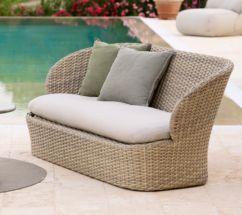 Coast lounge sofa with soft cushions, featuring a woven design in a sandy tone, perfect for relaxation by a poolside.