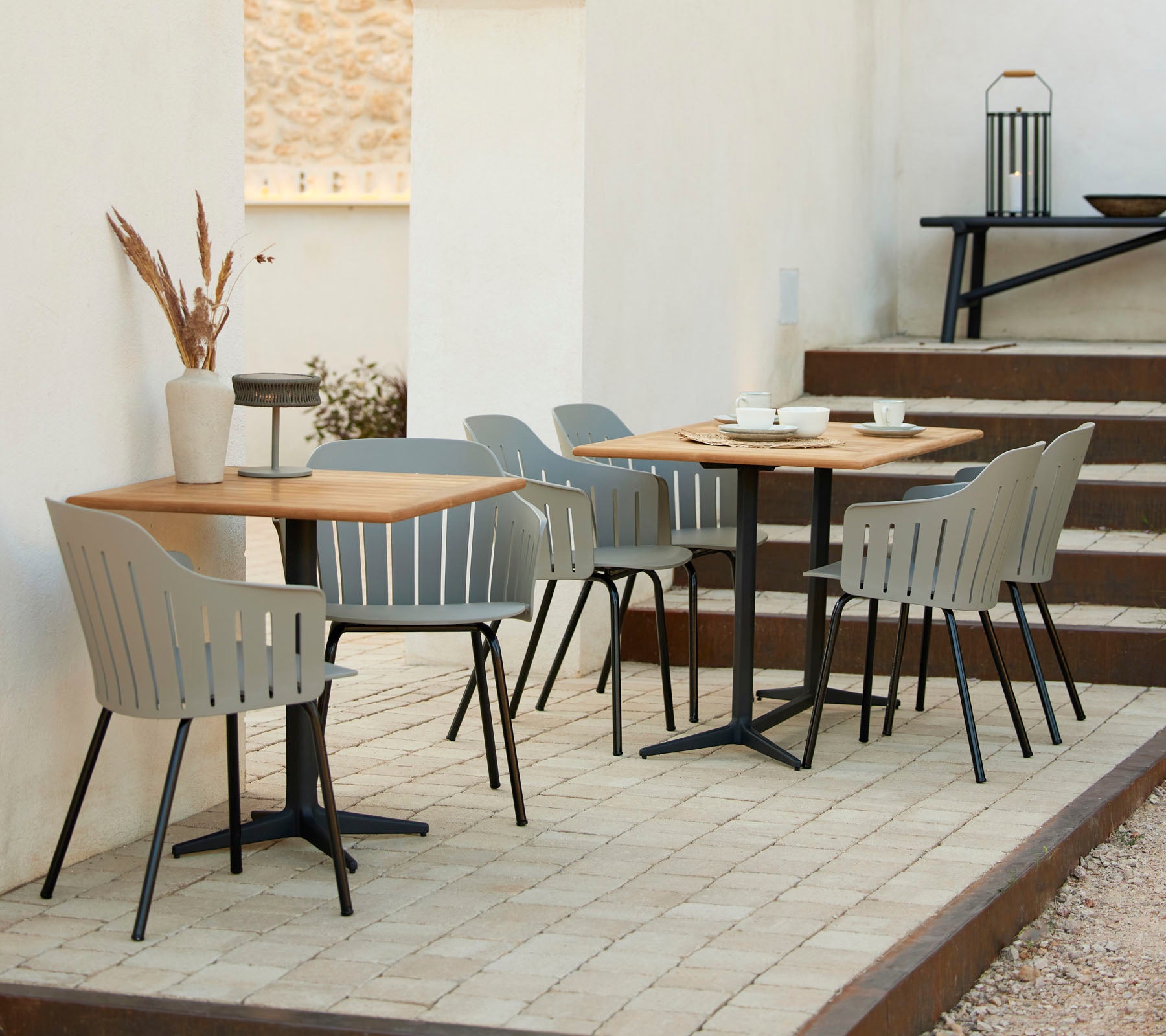 A stylish cafe setting with wooden tables, gray chairs, and decorative accents, ideal for casual gatherings and relaxation.