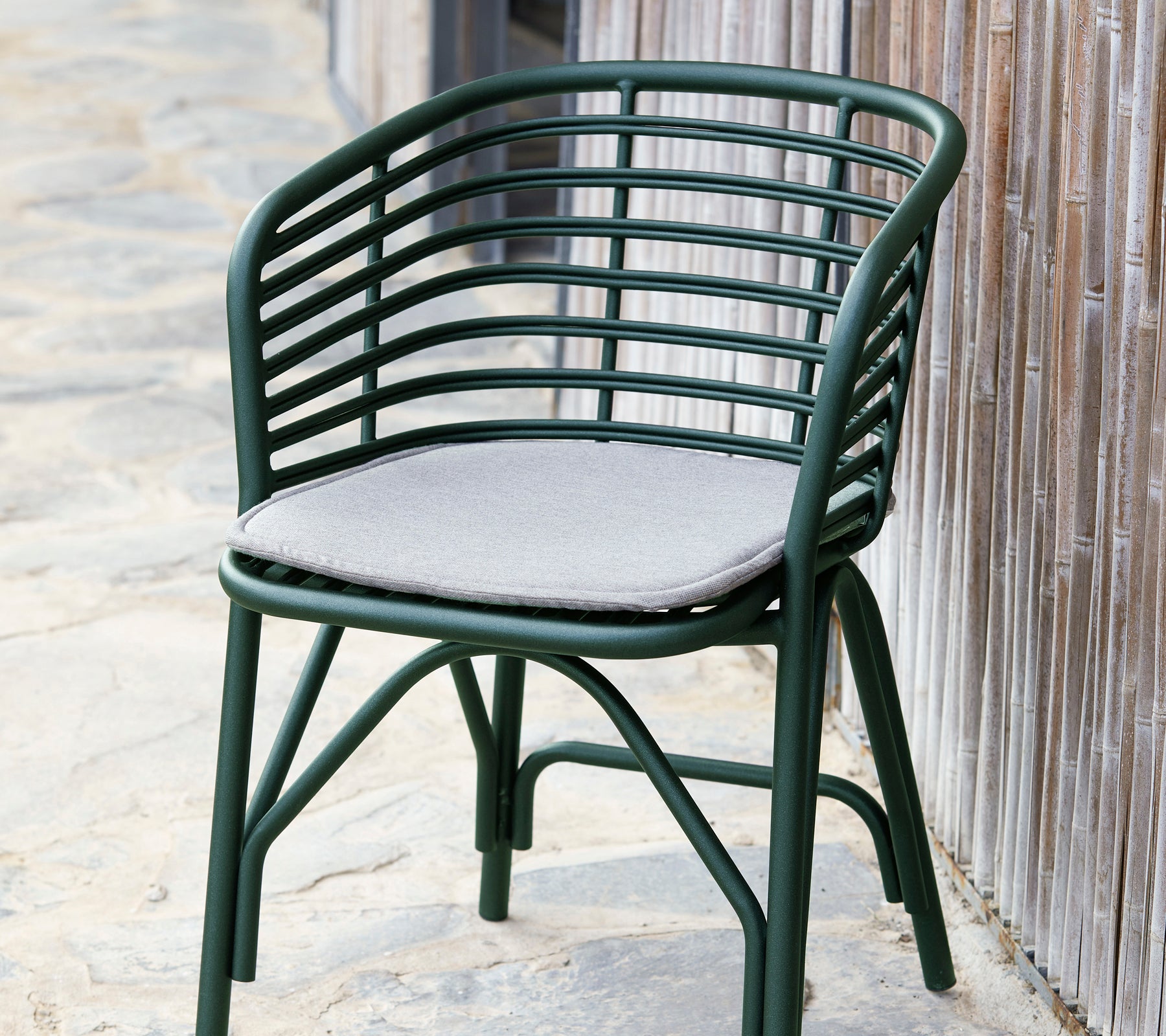 Green blend chair with a curved backrest and a soft gray cushion, designed for comfort and style.