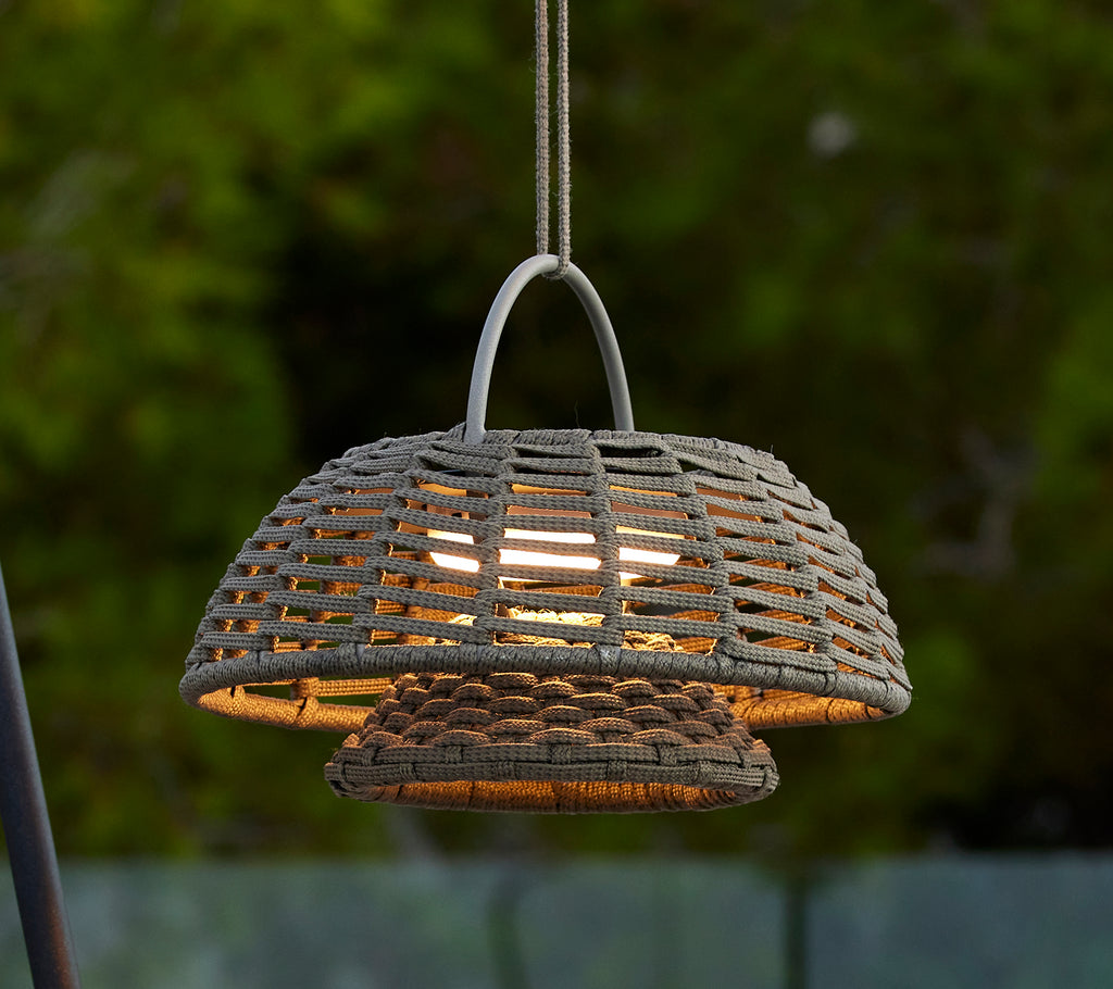 Taupe illusion lamp with a woven design, featuring a prominent dome shape and warm light emanating from within, creating an inviting ambiance.