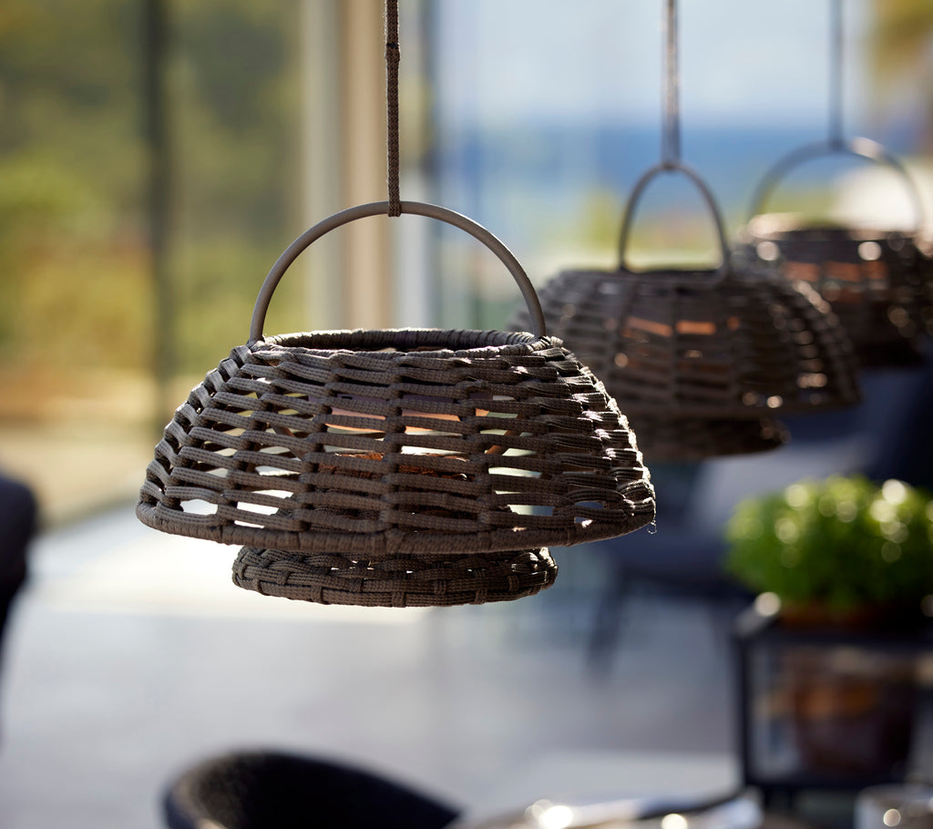 Illusion lamps in taupe hanging in a row, featuring a woven design with a circular shape and a minimalist aesthetic.