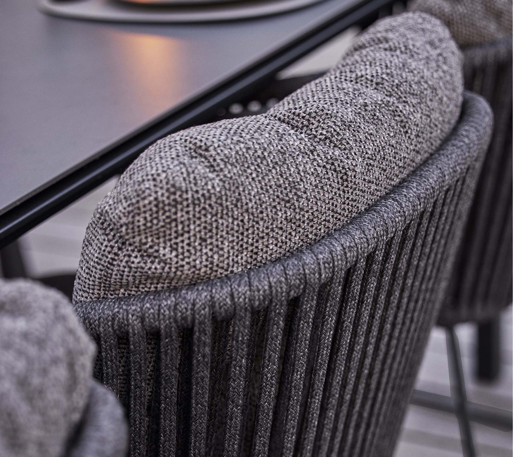 Close-up of a textured chair back with a soft, padded cushion, featuring a stylish vertical ribbed design.