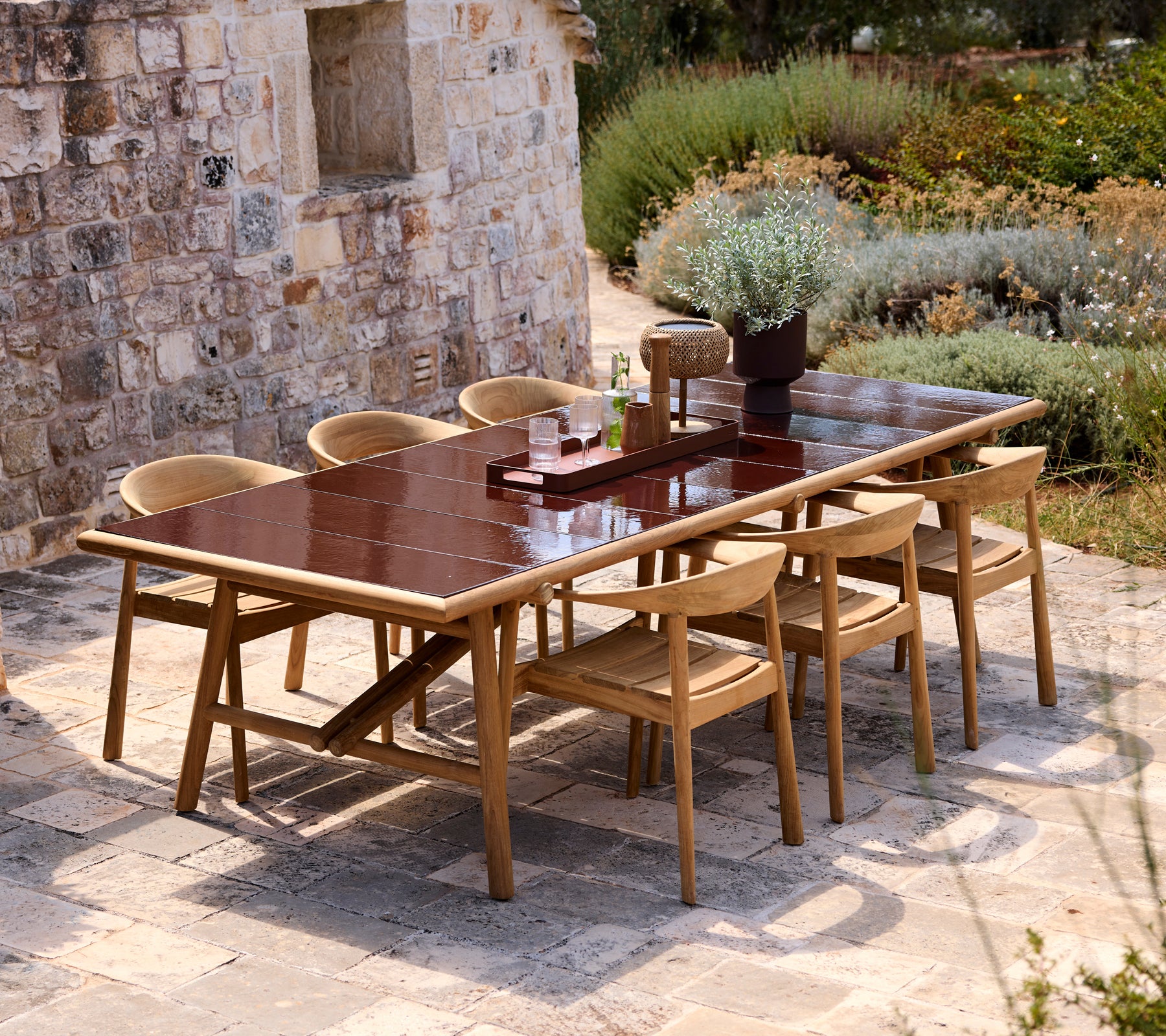 Brown dining table with beige chairs in a modern outdoor setting.