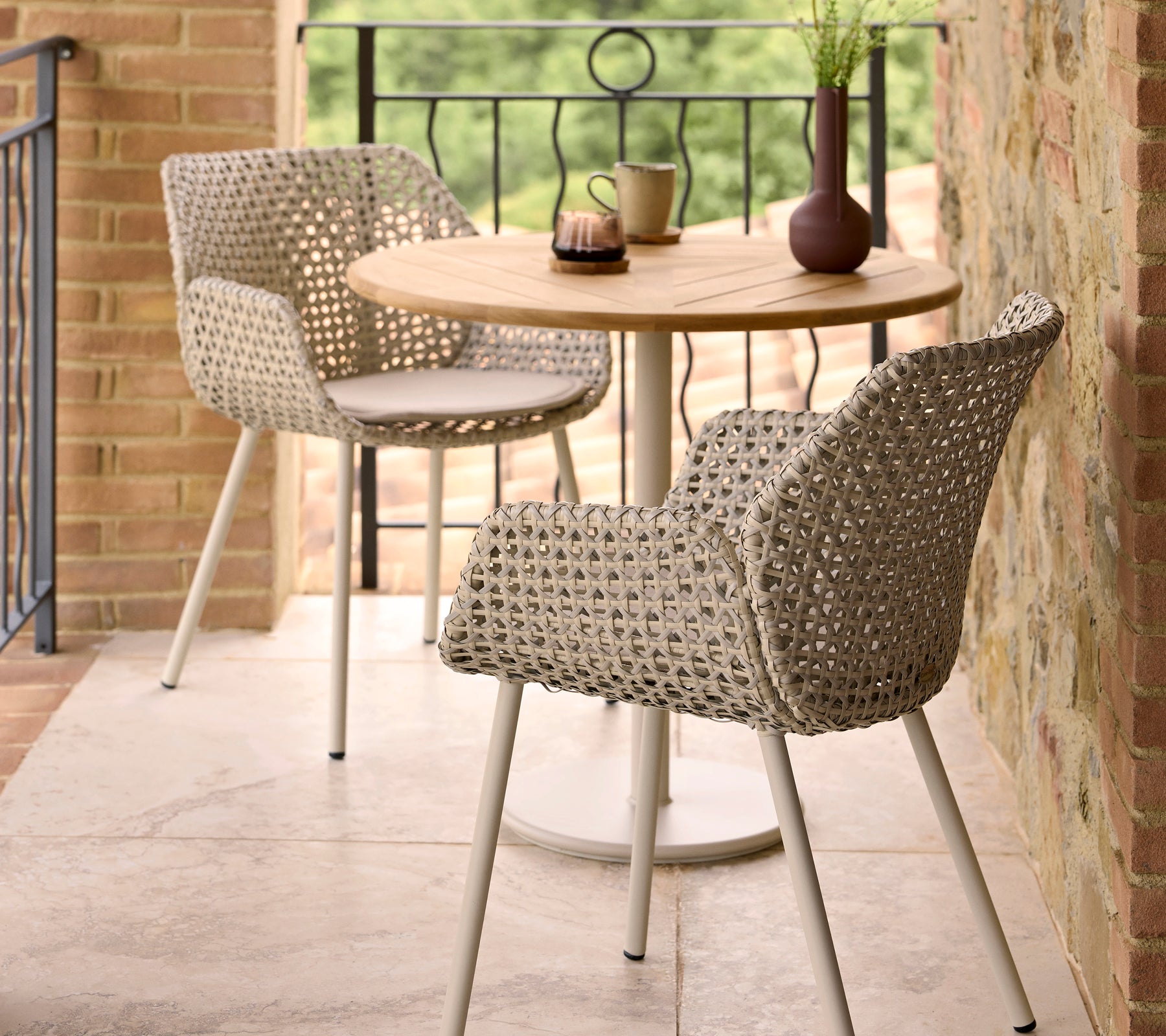 Stylish Vibe dining chairs paired with a round Go cafe table, complemented by decorative items on the table.